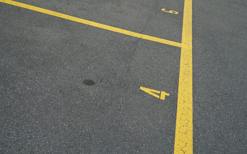 Places de stationnement numérotées et délimitées sur un parking